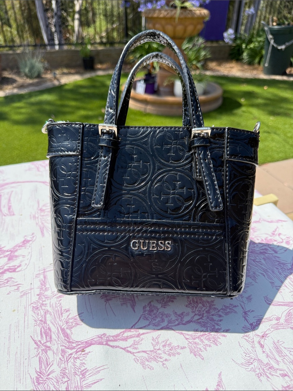 GUESS Delaney patent faux leather tote bag with an embossed logo pattern